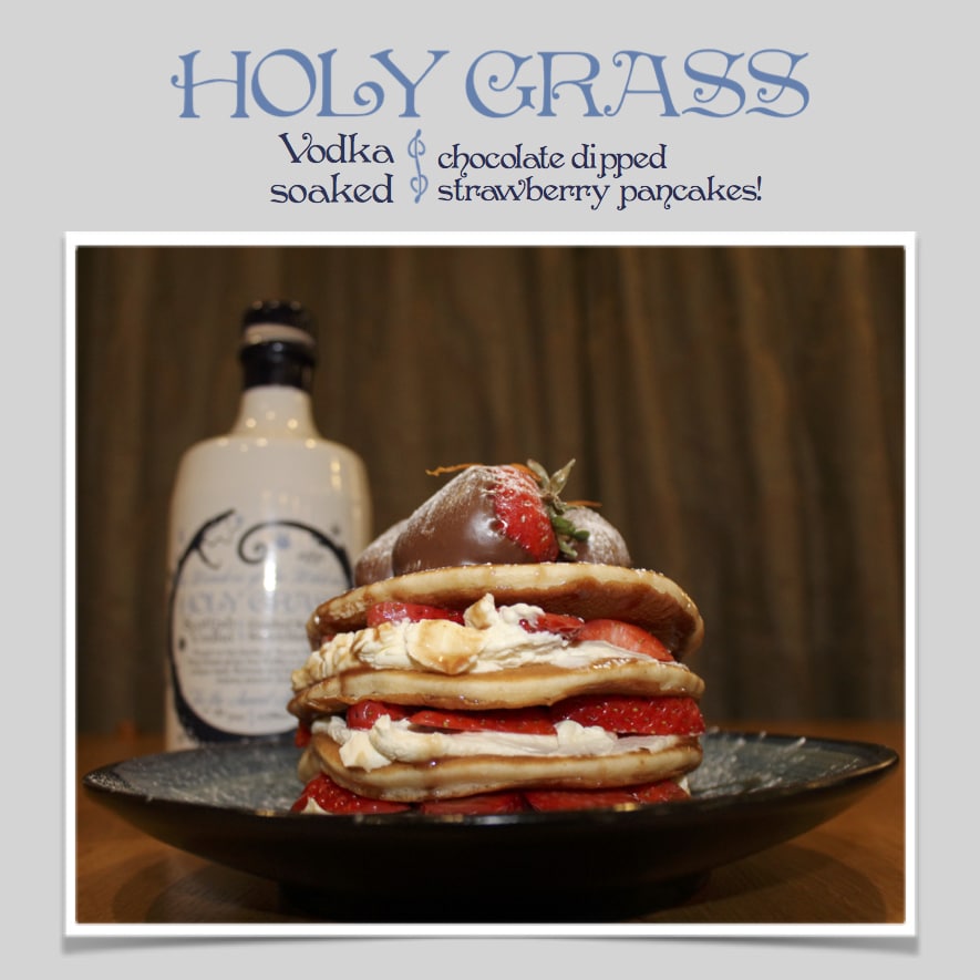Holy Grass Vodka strawberry pancakes on a plate topped with whipped cream, and chocolate dipped strawberries