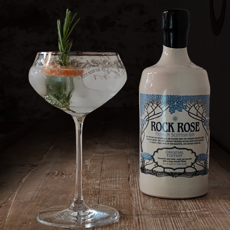 Rock Rose Gin cocktail and garnish served in a Rock Rose Gin branded coupe glass