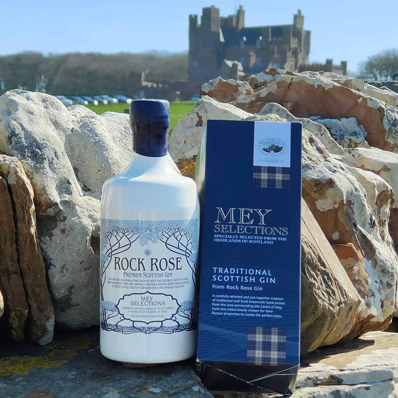 Bottle of Rock Rose Gin Mey Selections, traditional Scottish gin and its tartan box in front of the Castle of Mey