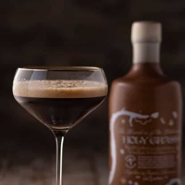 Bottle of Holy Grass Coffee Edition and Perfect Serve in a coupe glass