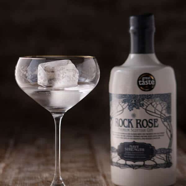 Bottle of Rock Rose Navy Strength and perfect serve in a coupe glass with ice cube