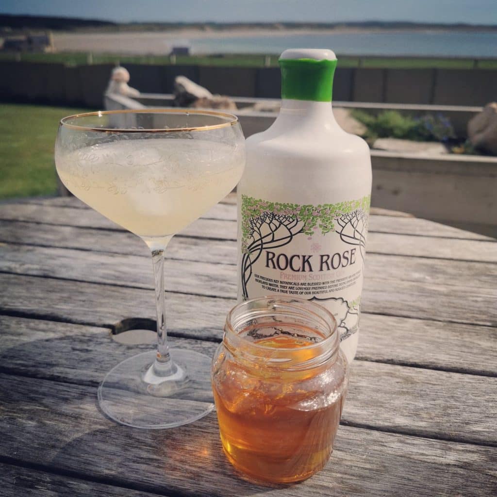 Bottle of Rock Rose Gin Summer edition, jar of marmalade and Spring Bees Knees cocktail served in a coupe glass