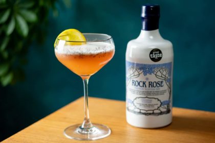Bottle of Rock Rose Gin and Paddington’s Negroni Sour Cocktail served in a coupe glass and garnished with slice of lemon
