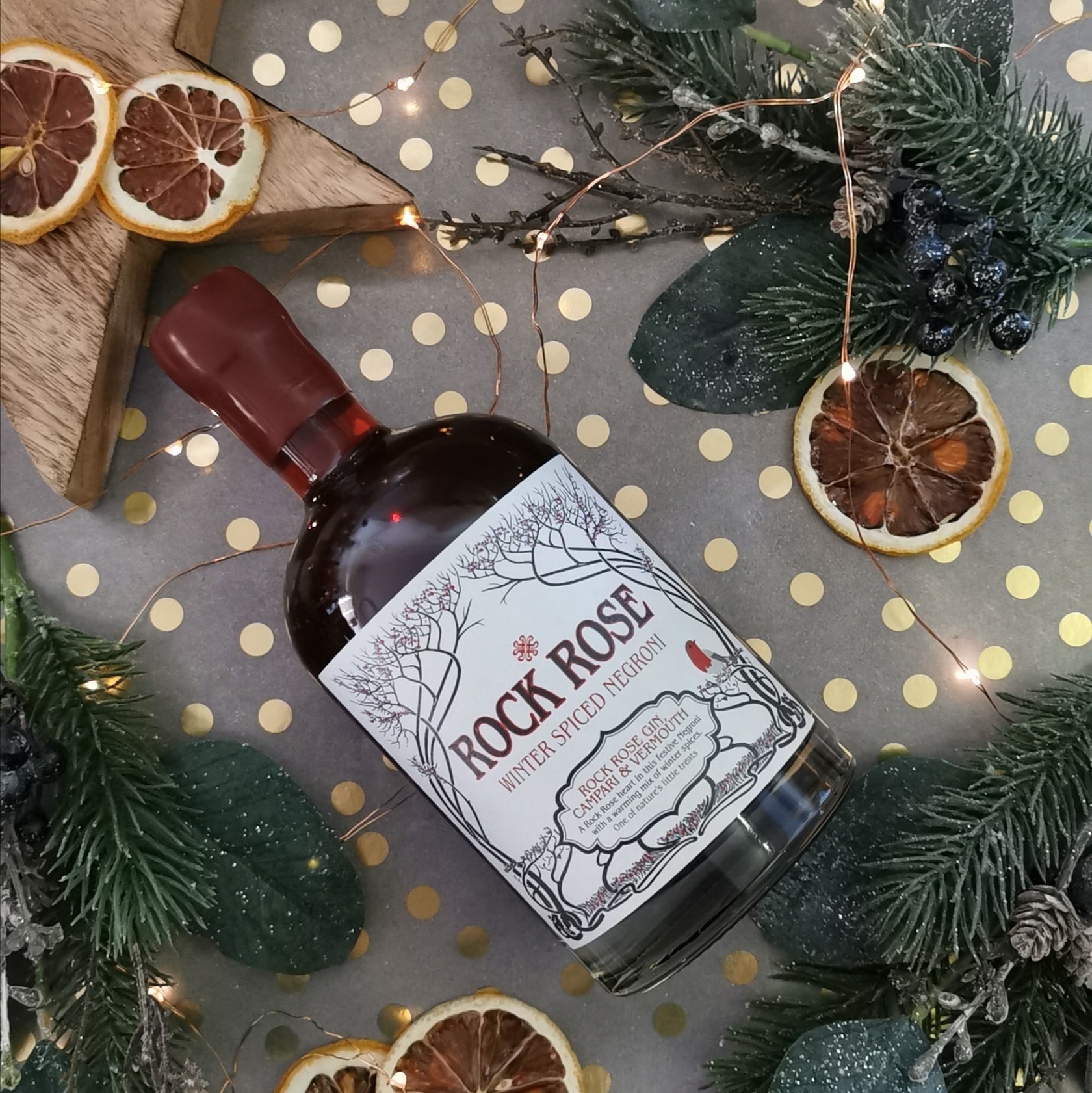 Bottle of Rock Rose Winter Spiced Negroni on a table with festive decoration