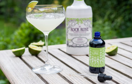 Bottle of Rock Rose Spring Edition and Lime liquid garnish with Lime in the Coconut Cocktail served in a coupe glass and garnished with a slice of lime