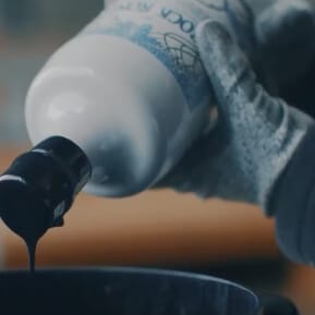 Hand holding a Rock Rose Gin bottle to apply wax on the cork