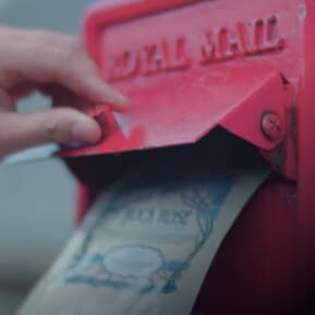 Hand sliding an empty refill pouch in a mailbox