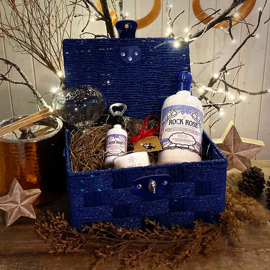 Blue hamper with bottle of Rock Rose Gin original, branded glass, bottle opener, small candle and a chocolate lollipop