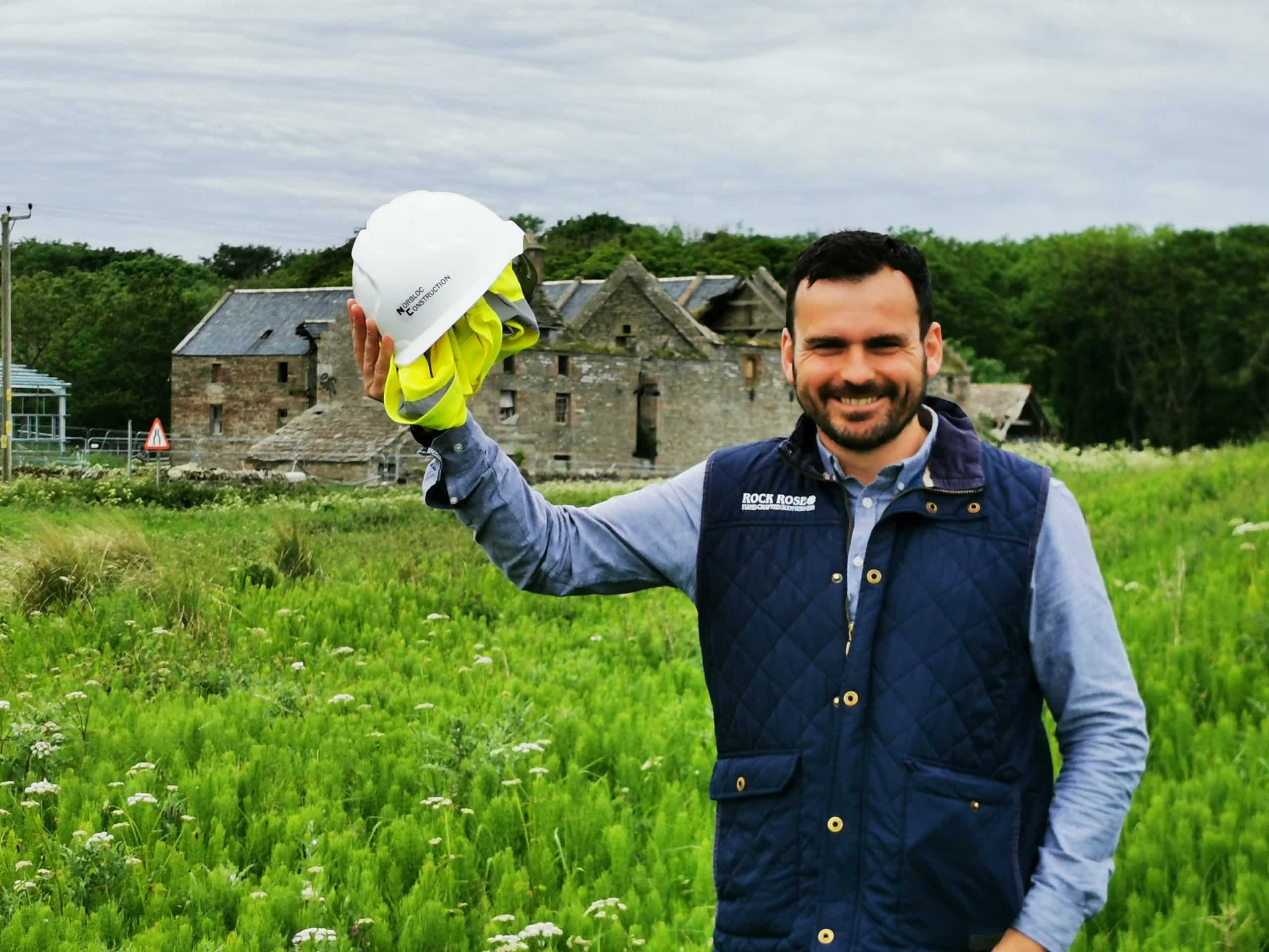 Martin holding a hard hat in front of the Castletown Mill building