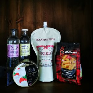 Content of the Refill Rewards Club box for July 2022 including Rock Rose Gin Pouch, tonic waters, Walkers mini shortbread fingers and Strawberry and cream sweeties