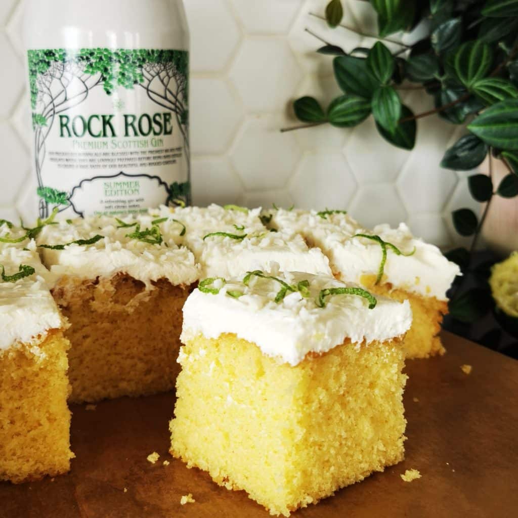 Bottle of Rock Rose Gin Summer Edition and Thai Gin Fizz cake iced with Lemongrass, Ginger syrup and Rock Rose Gin Summer Edition icing and sprinkled with desiccated coconut and lime zest.