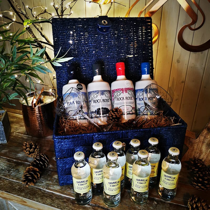 Content of The Signature Collection Hamper including a bottle of Rock Rose Gin Original Edition, and three bottles of Rock Rose special edition, 2 branded glasses and 8 tonic, in a blue hamper