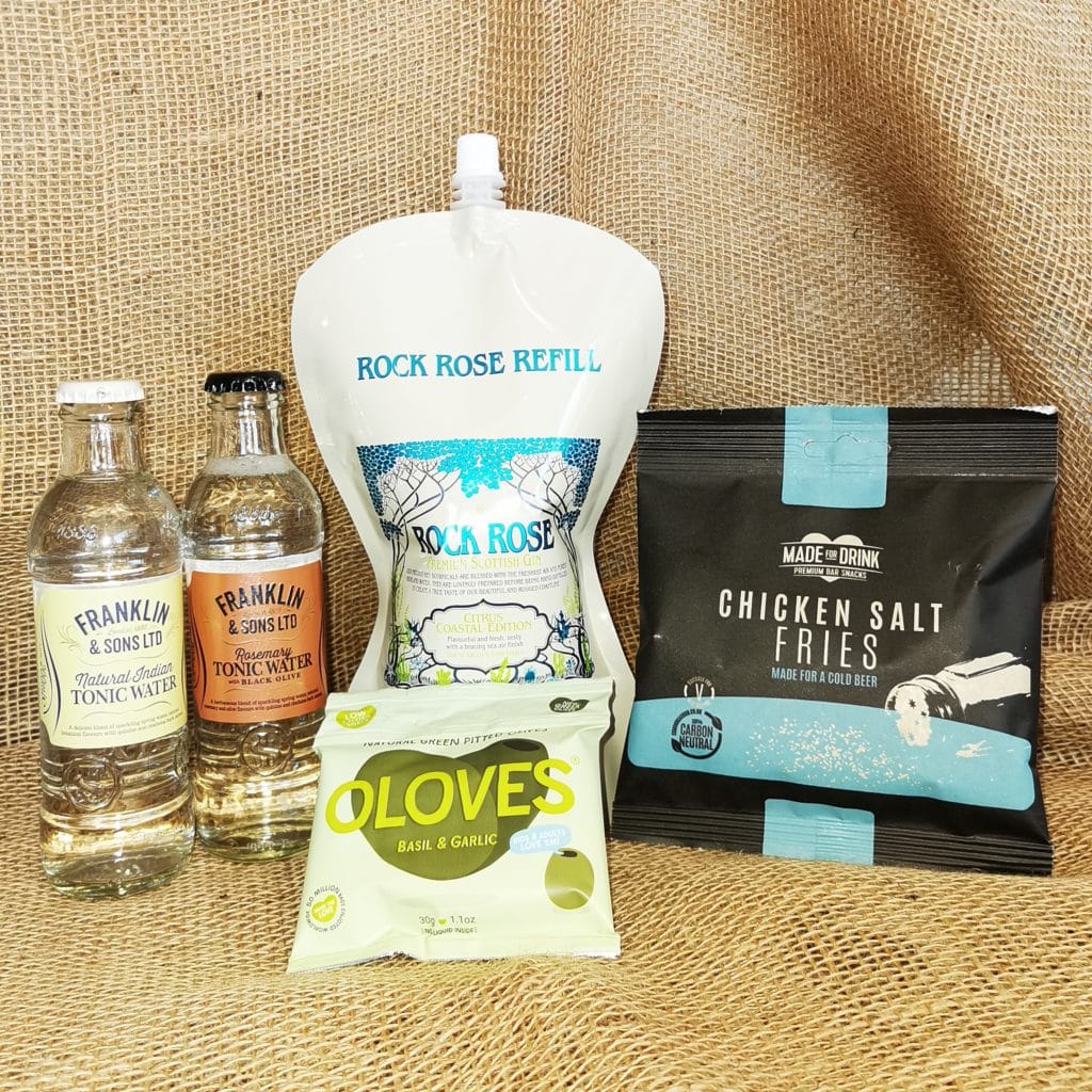 Content of the Refill Rewards Club box for November 2022 including Rock Rose Gin Citrus Coastal edition pouch, 2 tonic waters, chicken salt fries and basil and garlic pitted olives