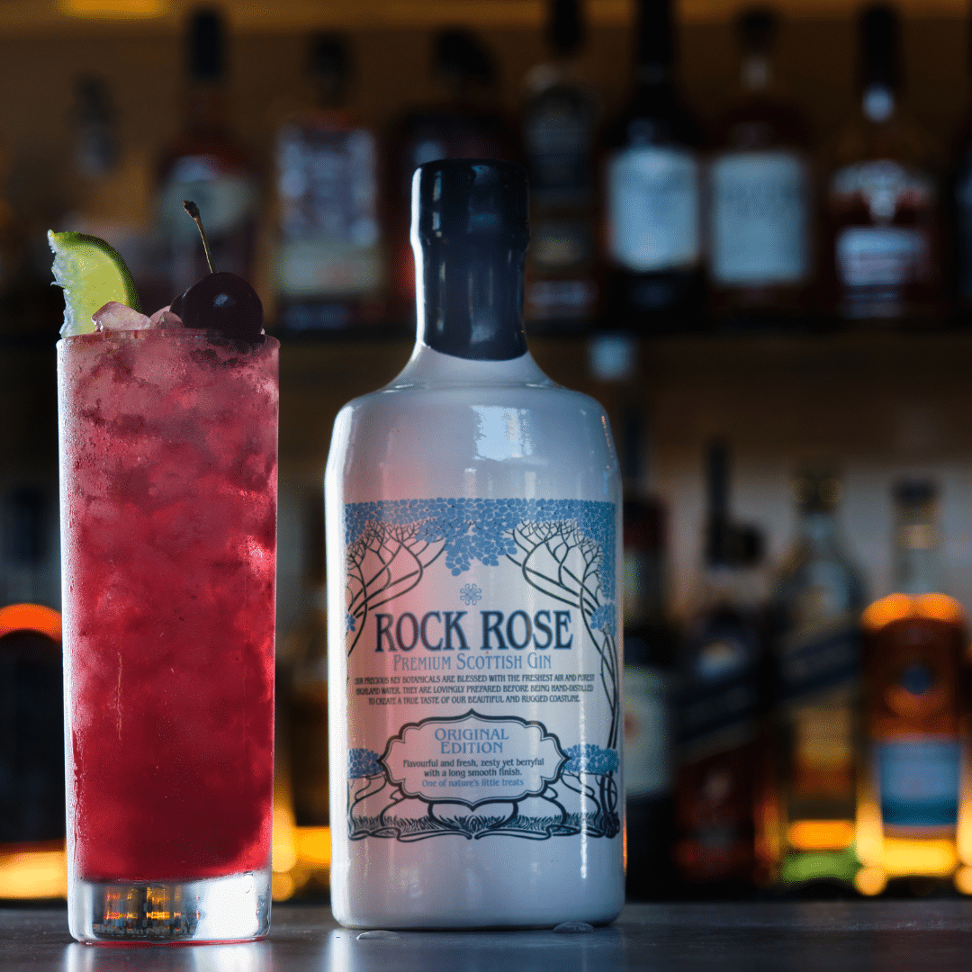 Rock Rose Gin original edition with Sour Cherry Gin cocktail served in a tall glass and garnished with lime and fresh cherries