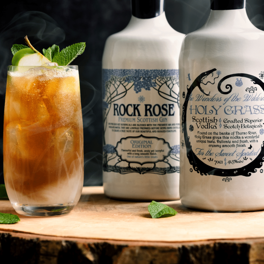 Bottles of Rock Rose Gin and Holy Grass Vodka original edition with Loch Highland Ice tea cocktail served on a tall glass with ice, slice of apple and min leaves