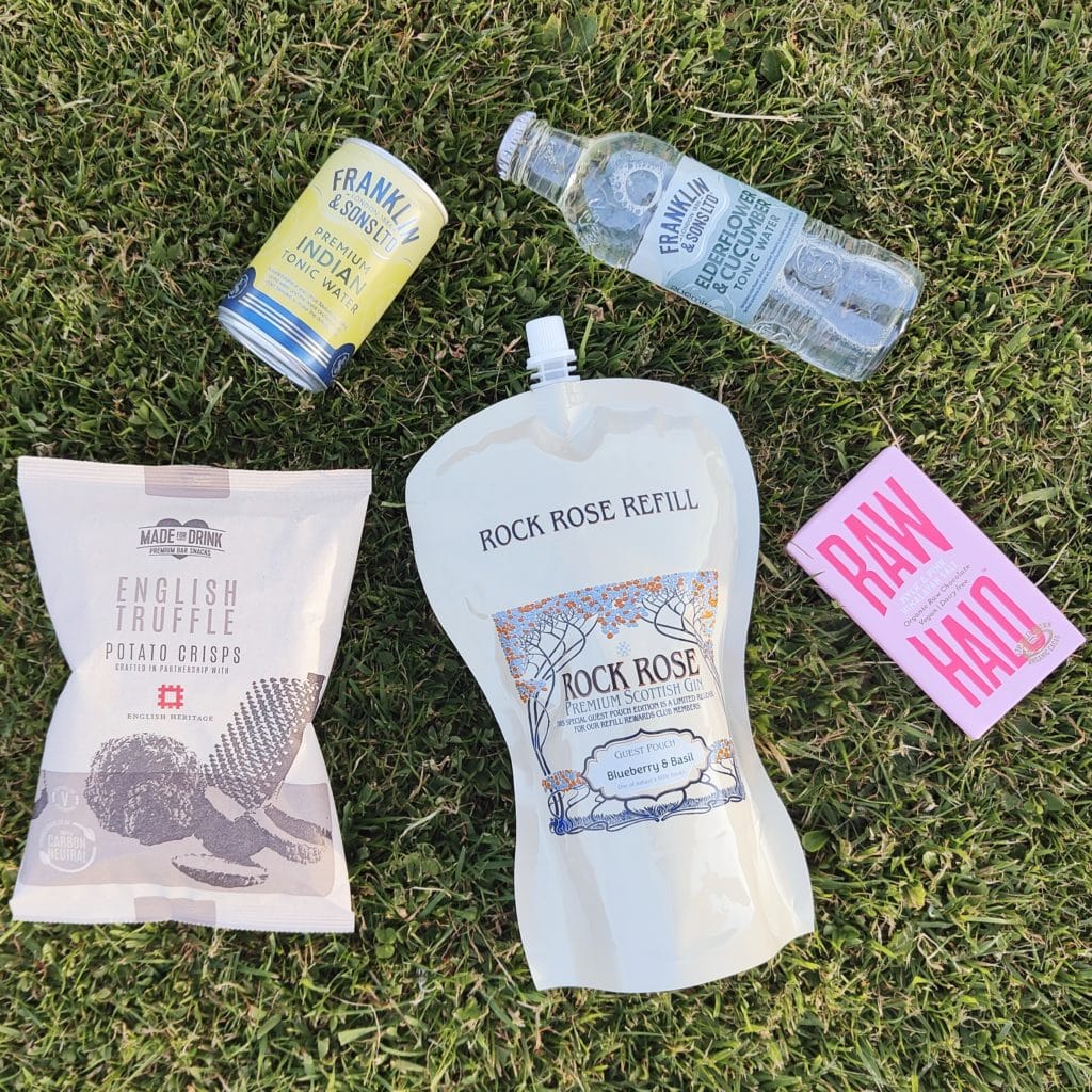 Content of the Refill Rewards Club box for June 2023 including Rock Rose Gin Blueberry & Basil Guest pouch, 2 Tonic water, English Truffle potato crisps and organic row chocolate bar